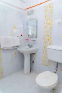 a white bathroom with a toilet and a sink at Hotel Victoriya Palace,Mcleod Ganj in McLeod Ganj +112 photos