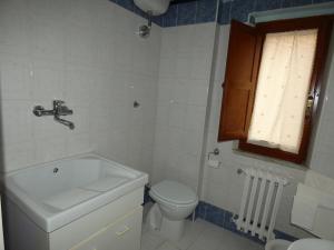 Un baño con lavabo, inodoro y ventana. en La Casa dei Ricordi, en Tito 15 fotos más