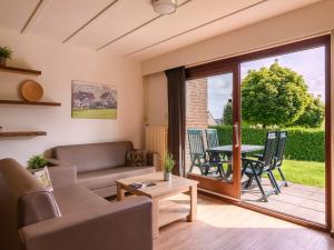 a living room with a couch and a table at Bungalow in Reevallis near Scenic Hills in Vijlen