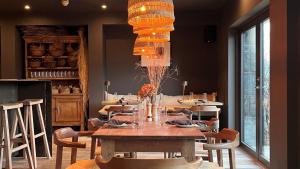 a dining room with a table with chairs and a chandelier at Fiddle + Bow Hotel in Doolin +23 photos