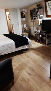 een slaapkamer met een bed en een houten vloer bij le Jardin in Dinard