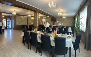 a dining room with tables and chairs in a room with people at Pensiune cu restaurant Bigfast in Luduş