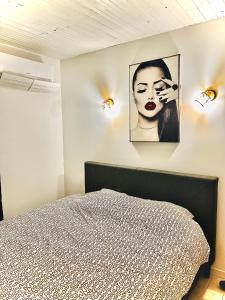 a bedroom with a bed and a picture of a woman at Villa avec Spa & Sauna, Évasion in Béziers +25 photos