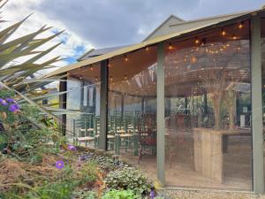 a glass house with a table and chairs in it at Fiddle + Bow Hotel in Doolin