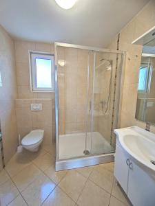 a bathroom with a shower and a toilet and a sink at Apartments Mia in Baška +36 photos