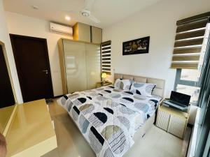 ein Schlafzimmer mit einem Bett und einem Laptop auf einem Tisch in der Unterkunft Colombo luxury two bedroom Apartments Trizen in Colombo + 15 Fotos