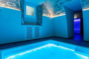 a swimming pool in a room with blue lighting at ELESOR & Spa in Modica