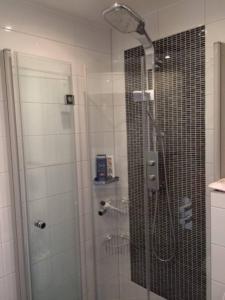 a bathroom with a shower with a glass door at Nice and cosy house close Amsterdam and airport in Badhoevedorp