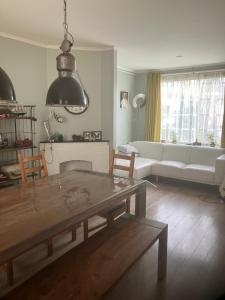 a living room with a table and a couch at Nice and cosy house close Amsterdam and airport in Badhoevedorp