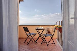 a table and chairs on a balcony with a view of the ocean at Cortona Skyline Retreat in Cortona