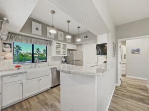 Una cocina con gabinetes blancos y una isla grande. en Saguaro #202 Fountain Hills, en Fountain Hills