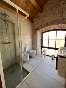 a bathroom with a glass shower and a toilet at NUOVA FILANDA Rooms and More in Valdobbiadene