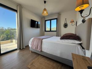 a bedroom with a bed and a large window at Residence I Pozzi in Belgodère