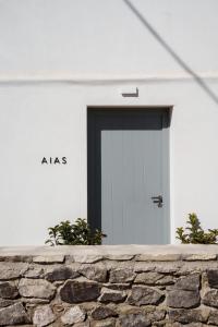 a white house with a door in a stone wall at Poema Antiparos in Antiparos