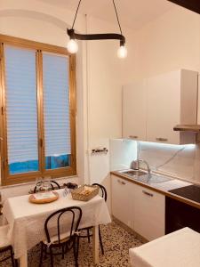 a kitchen with a table and some chairs and a table at Appartamento retrò-chic in La Spezia in La Spezia