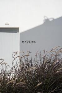 a sign in front of a building with some grass at Poema Antiparos in Antiparos