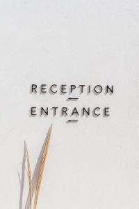 a sign that reads reception entrance with a plant at Poema Antiparos in Antiparos +37 photos