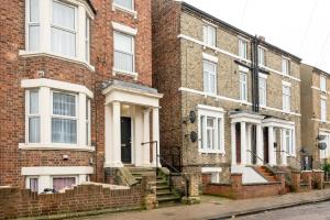 a brick building with white windows on a street at The Cozy Two beds, FREE parking, SKY in Bedford