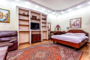 a bedroom with a bed and a tv and a couch at Arbat апартаменты в центре города - выбор для туриста и деловых поездок in Almaty