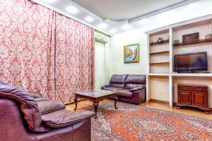 a living room with a couch and a tv at Arbat апартаменты в центре города - выбор для туриста и деловых поездок in Almaty