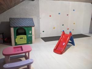a play room with a slide and a play house at Appartement et salle de jeu in Saint-Claude