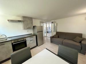 eine Küche und ein Wohnzimmer mit einer Couch und einem Tisch in der Unterkunft Il Villino Lido Spina - Monolocale 2 persone in Lido di Spina