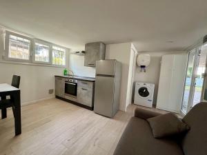 eine Küche mit einem Kühlschrank aus Edelstahl und einem Tisch in der Unterkunft Il Villino Lido Spina - Monolocale 2 persone in Lido di Spina