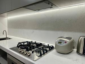 einen Küchenherd mit einem Toaster darüber in der Unterkunft Melbourne 380 Lonsdale Apartment in Melbourne + 12 Fotos