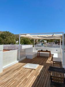 a deck with a table and chairs on a roof at Duplex con terraza en Agua Amarga in Agua Amarga