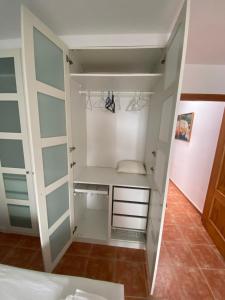 a walk in closet with white walls and glass doors at Duplex con terraza en Agua Amarga in Agua Amarga