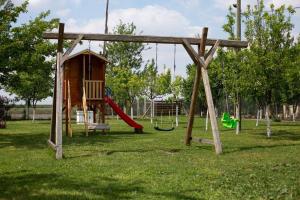 a playground with a slide and a swing at Pansion Sašin Salaš 40m2 in Rumenka