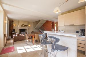 a kitchen and living room with a table and chairs at La Maison de Maître, la plus grande des 3 maisons du Clos d'Isand'Or in Meursault