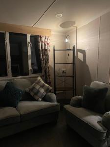 a living room with a couch and a chair at Lakes Escapes in Lamplugh