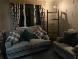 a living room with a couch and a window at Lakes Escapes in Lamplugh