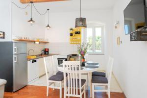 a kitchen with a table and chairs in a room at Historic Stone Home On The Seafront With King Beds And Garden in Stari Grad