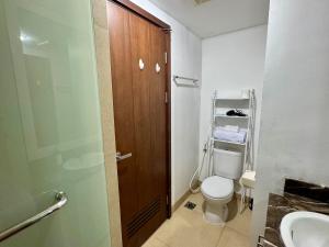 a bathroom with a toilet and a sink and a shower at Cozy Studio U Residence 2 - Netflix and WiFi in Klapadua +5 photos