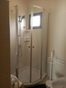 una doccia con una porta in vetro in un bagno di Vilas Horizonte a Porto Santo Altre 20 foto