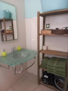 un bagno con lavandino, specchio e asciugamani di Vilas Horizonte a Porto Santo