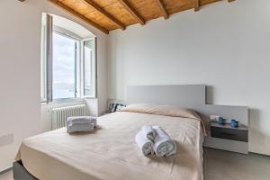 a bedroom with a bed with towels on it at Eldorado,Romantic Seafront Getaway in Manarola