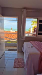 a bedroom with a bed and a view of the ocean at Pousada America do Sol in Natal
