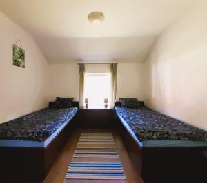 Dos camas en una habitación con ventana. en Dom nad Jeziorem Łaśmiady, en Sajzy