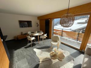 a living room with a table and chairs and a window at Appartement Nendaz, bâtiment Diana in Nendaz
