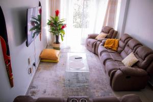 a living room with a brown couch in a room at Bellissima Homes in Kericho