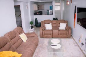 a living room with two brown couches and a table at Bellissima Homes in Kericho