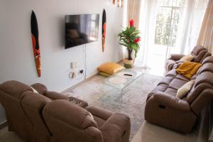 a living room with two couches and a tv at Bellissima Homes in Kericho