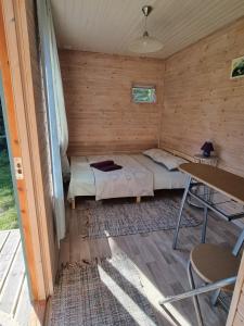 a small room with a bed and a table at Camping Zvejnieksēta in Pāvilosta +90 photos