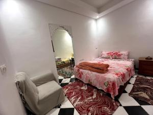 a bedroom with a bed and a chair and a mirror at Mini Studio in Marrakech