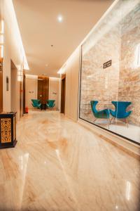 vestíbulo con sillas azules y pared de cristal en كنين للشقق الفندقية-Kanin Apartments, en Riad