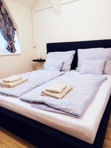 a large bed with two towels on top of it at Chili Apartman in Harkány