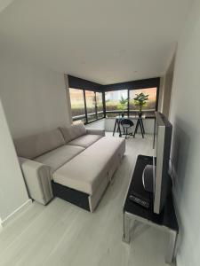 a living room with a couch and a flat screen tv at Cascais Atrium Seafront Apartment - Pool, Spa & Tennis in Cascais